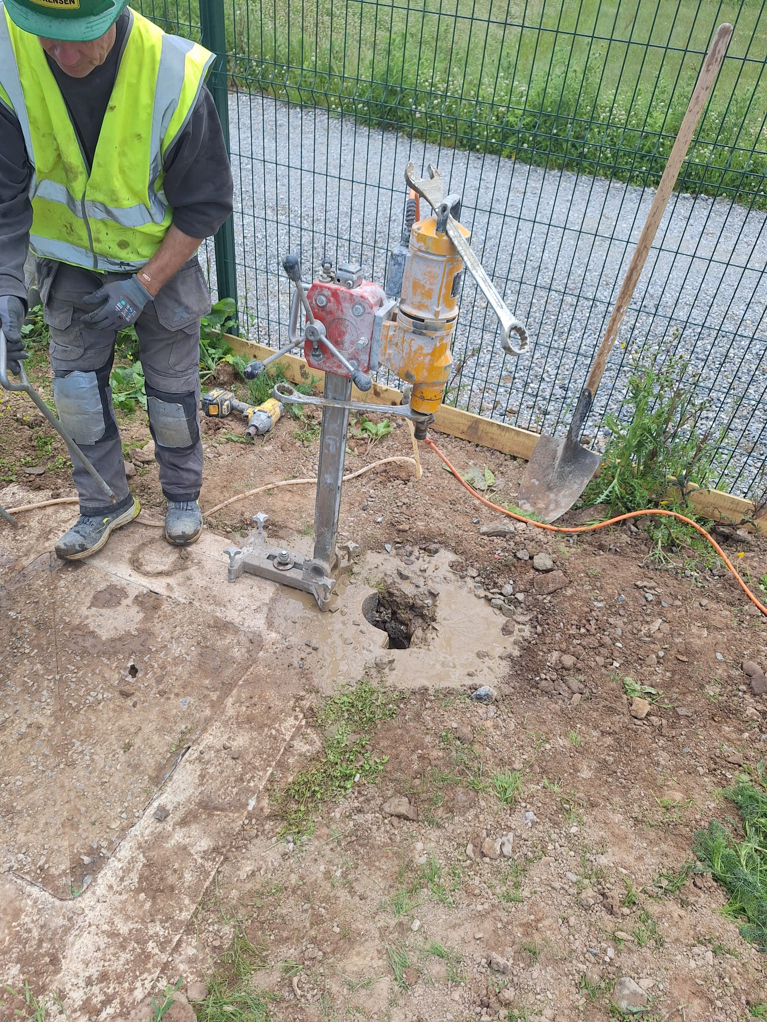Diamond core drilling through concrete slab — cored opening for drainage and manhole access on a residential civil site, Munster